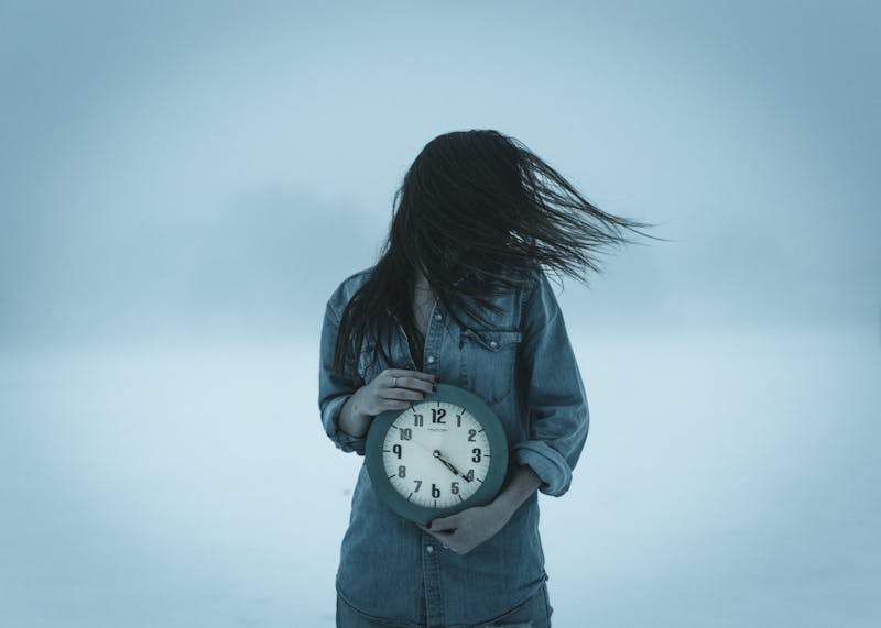 A girl holding a clock.