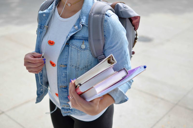 A student standing with books.