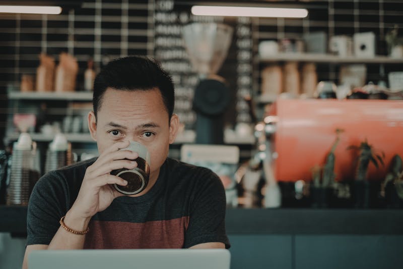 A man sipping coffee in a coffee shop