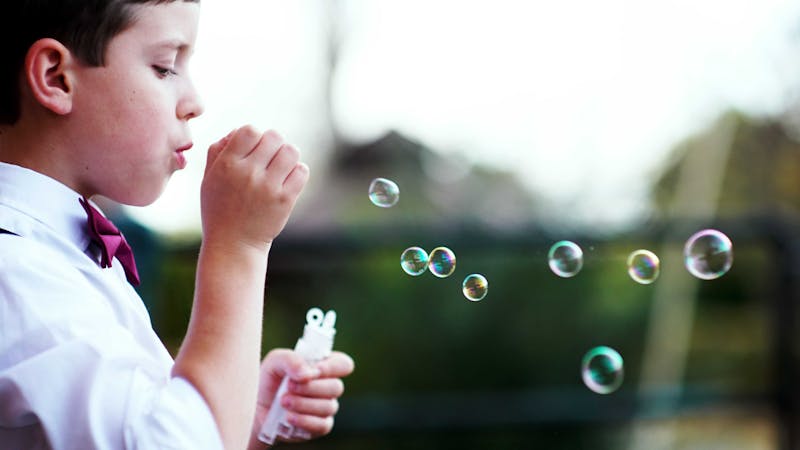 A boy blowing bubbles.