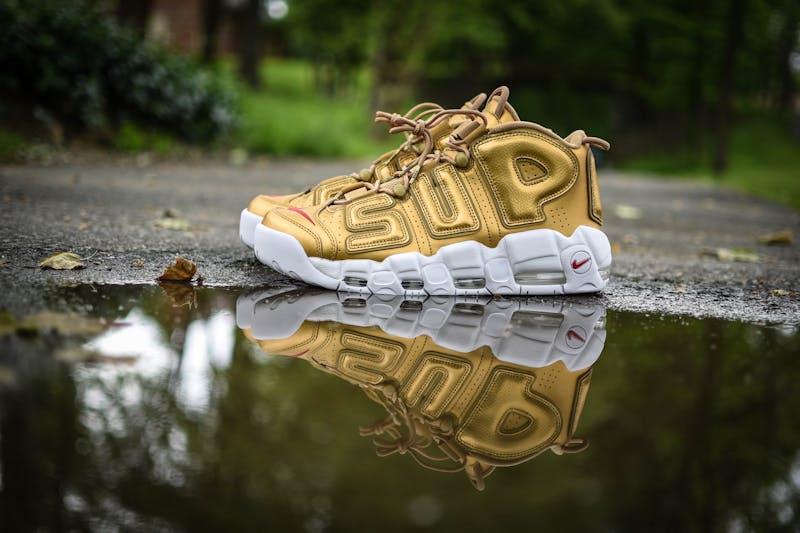 a single yellow takkie next to a puddle of water with SUP written on it