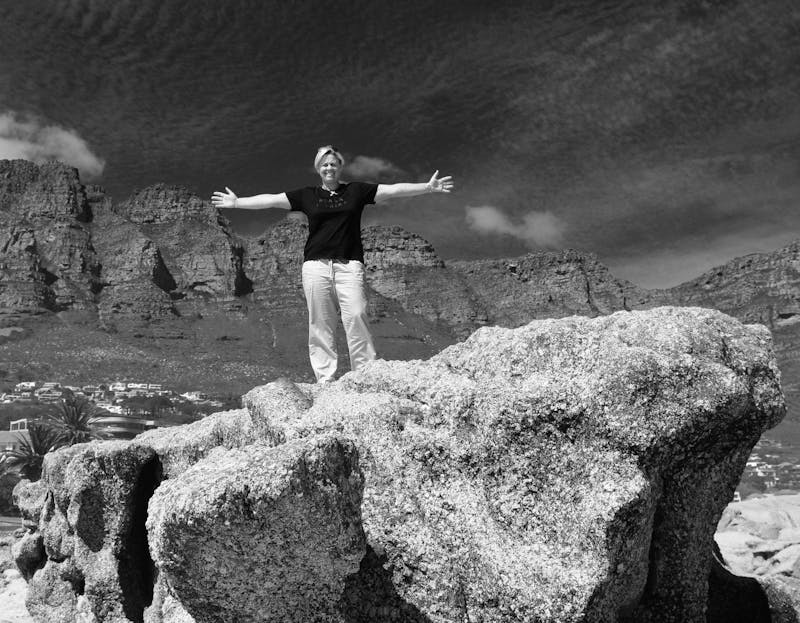 Anita at Camps Bay standing on a rock.