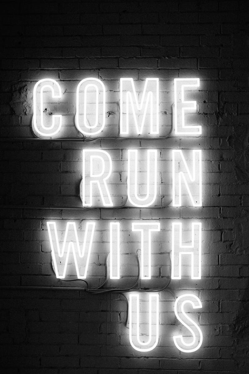 A neon sign that says "come run with us".