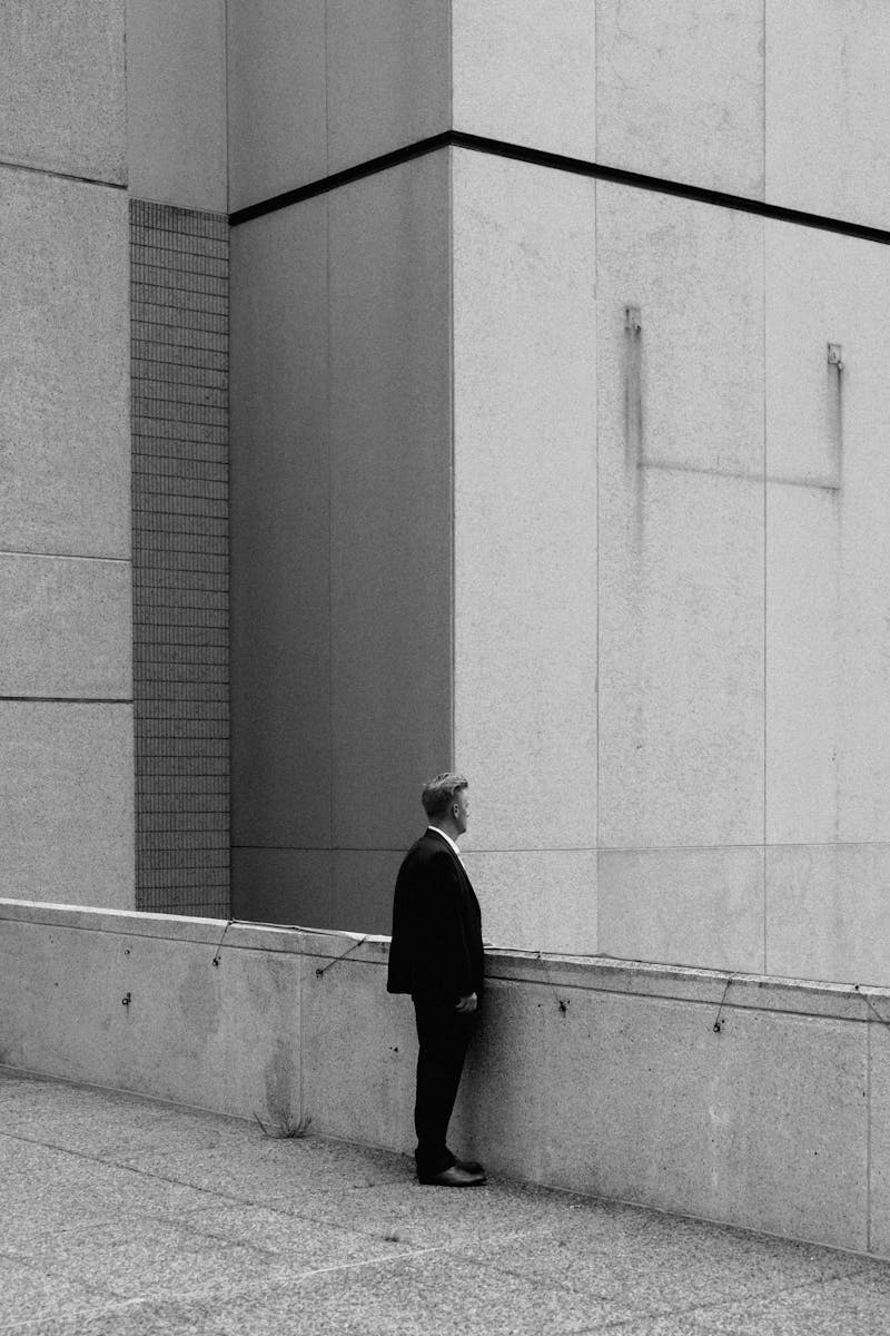 Man looking out from a balcony on a building. In black and white.