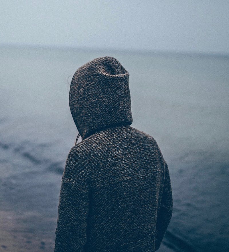 Girl with hoody at beach.