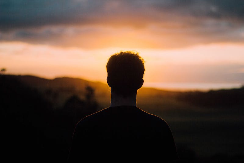 guy with his back to the camera at sun set