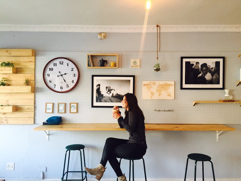 Girl sitting with cup of coffee smiling.