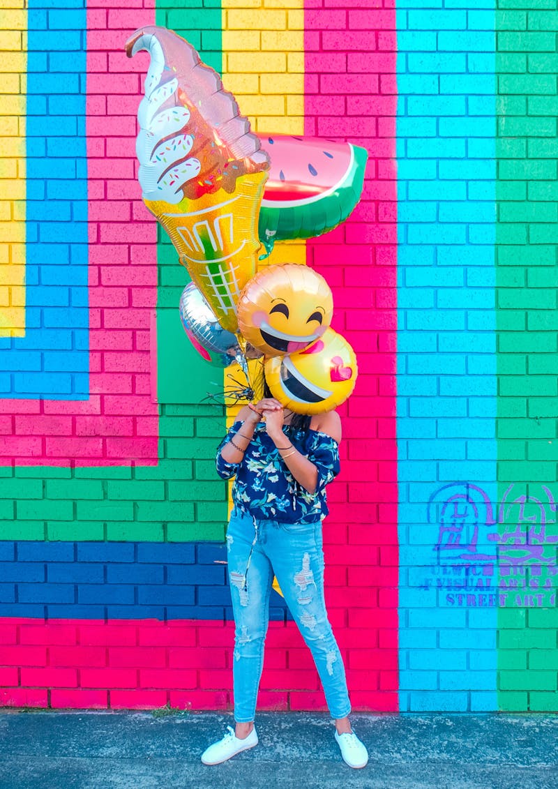 A very colourful picture of a girl holding balloons