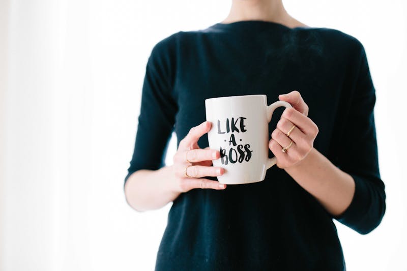 A woman holding a mug with "like a boss" printed on it.