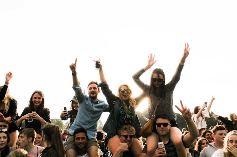 Music festival. Girls on shoulders of guys.