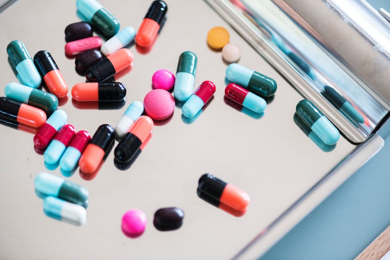 Lots of pills laying on something that looks like a clipboard.