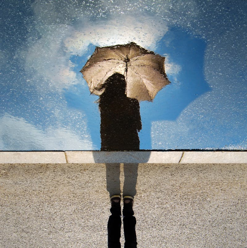 Reflection of a woman in a pool of water.