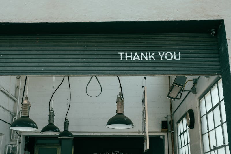 A green roll-up serranda with the words "Thank you" painted on it.