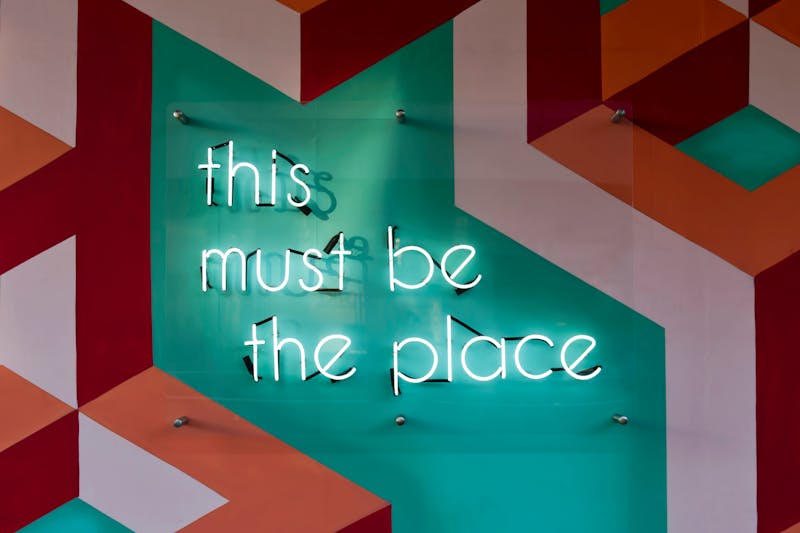 A neon sign that reads "this must be the place".
