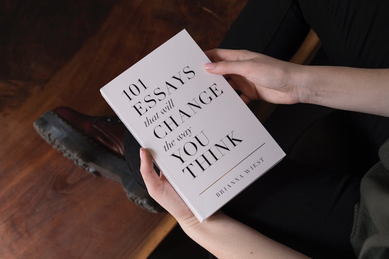 A person holding a book that says 1001 essays that will change your mind