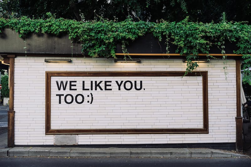 Text on a wall that reads "WE LIKE YOU TOO.".