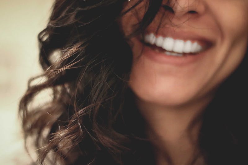 A woman laughing. You can't see her whole face.