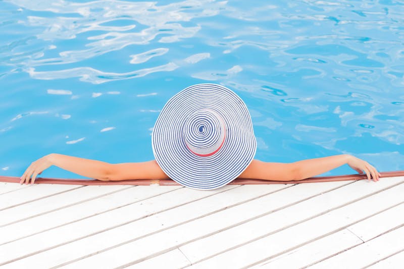 Woman with hat at the pool.