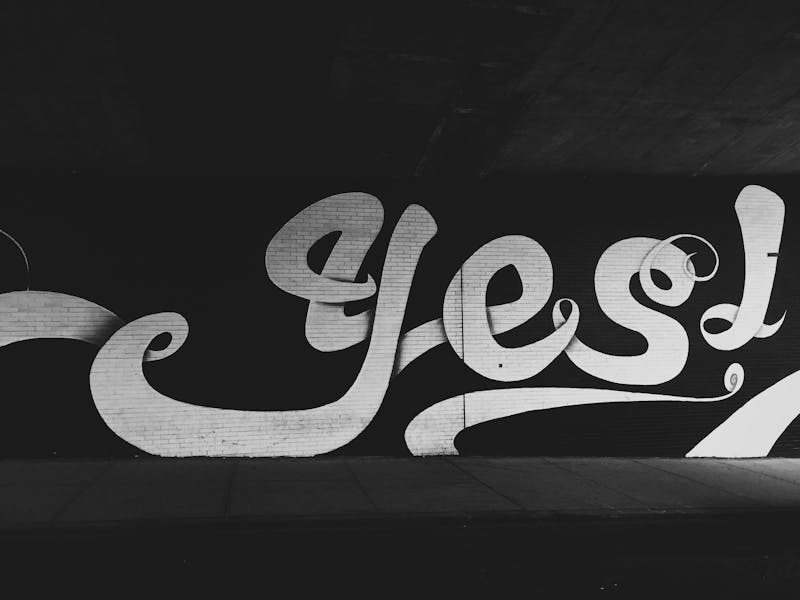 Grafitti on a wall that reads "yes!".